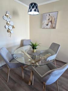a dining room with a glass table and chairs at Rancagua Lujo y comodidad Depto con Piscina y Estacionamiento in Rancagua