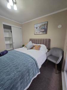 a bedroom with a bed and a chair at Rancagua Lujo y comodidad Depto con Piscina y Estacionamiento in Rancagua +15 photos