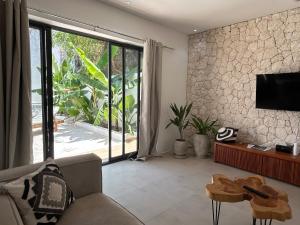 a living room with a television and a couch and a table at U Paradisu Villas-Jambiani in Kibigija