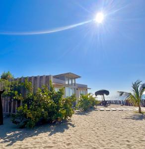 a building on the beach with the sun in the sky at Ribera Del Norte Bungalows in Canoas