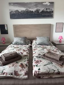 Dos camas una al lado de la otra en un dormitorio. en Apartment Tatry in the center of Poprad with view, en Poprad