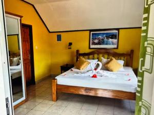 a bedroom with a bed with white sheets and a mirror at Relax in Paradise in Victoria