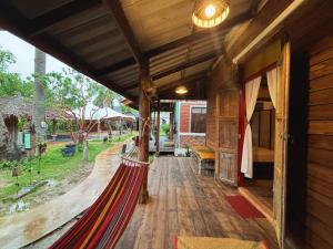 porche de una casa de madera con hamaca en Sanctuary Hostel - Art & Adventure, en Phra Ae beach 20 fotos más