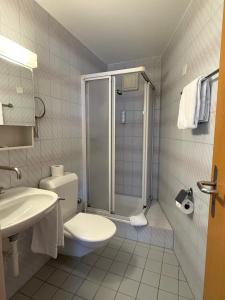 Un baño con ducha, inodoro y lavabo. en Hotel Aeschi Park, en Aeschi 65 fotos más