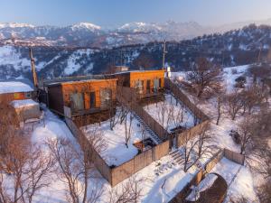 een huis op een heuvel in de sneeuw bij AlmaHouse Secluded Mountain Cabins in Alma-Ata