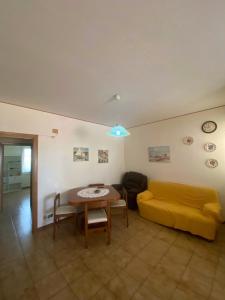 Crateri e coralli في ماسكالي: غرفة معيشة مع أريكة صفراء وطاولة