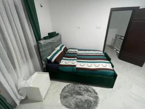 Dormitorio con cama con espejo y alfombra en Trinity Apartments, en Lekki