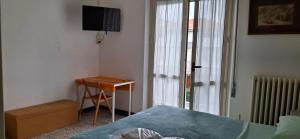 ein Schlafzimmer mit einem Bett, einem Schreibtisch und einem Fernseher in der Unterkunft B&B GALLETTO in Porto San Giorgio
