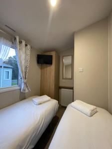 En eller flere senge i et værelse på Modern caravan - Whitecliff Bay