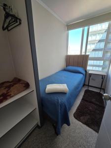 ein kleines Schlafzimmer mit einem blauen Bett und einem Fenster in der Unterkunft Rancagua Centro Departamento 3 dormitorios excelente ubicacion in Rancagua
