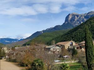 un pueblo en las montañas con una montaña en el fondo en Hotel Turmo, en Labuerda