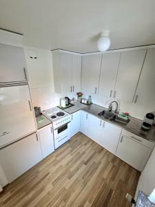a small kitchen with white cabinets and a sink at M & M home in Karlshamn