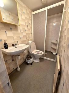 a bathroom with a white toilet and a sink at M & M home in Karlshamn