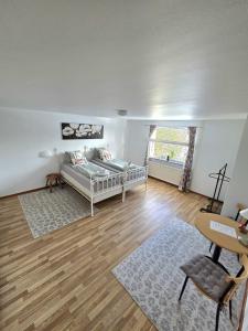 a living room with a bed and a desk and a window at M & M home in Karlshamn