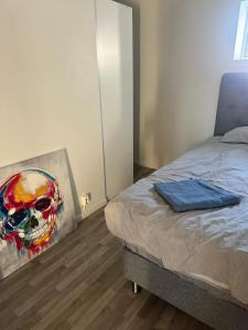 SvenljungaにあるVilla Feliz Holsljunga, Svenljunga & Ullaredのベッドの横に頭蓋骨の絵が飾られた寝室