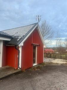 SvenljungaにあるVilla Feliz Holsljunga, Svenljunga & Ullaredの赤いドアと柵のある赤い納屋