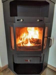 une cuisinière avec une cheminée à l'intérieur dans l'établissement Ferienwohnung KIostermühle Irsee - Parkplätze, Spielplatz, Biergarten, Badesee, E-Auto Ladepunkt, à Irsee