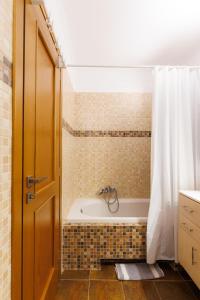 Un baño con bañera y cortina de ducha. en Peace View Kea, en Péra Meriá 24 fotos más