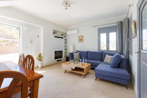 Una sala de estar con un sofá azul y una mesa. en Peace View Kea, en Péra Meriá