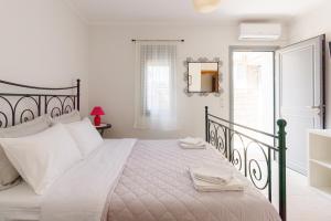 1 dormitorio blanco con 1 cama grande con almohadas blancas en Peace View Kea, en Péra Meriá