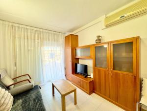 ein Wohnzimmer mit Sofa und Fernseher in einem Zimmer in der Unterkunft Apartsalou Zen in Salou