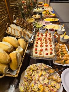 a buffet with many different types of bread and pastries at NAVEGA BEACH HOUSE - Casa 2 Andares - Rede Navega Hotéis in Navegantes +27 photos