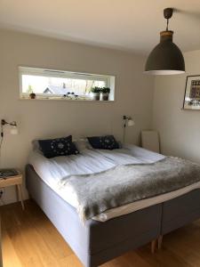 Una cama grande en un dormitorio con ventana. en Stunning, modern home with a lakeview, en Äspered