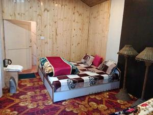 Un dormitorio con una cama y una lámpara. en TTN - The Trekker's Nest, en Jyotirmath