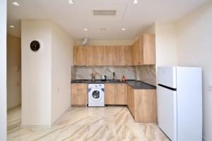 a kitchen with wooden cabinets and a white refrigerator at Your Yerevan Home in Yerevan