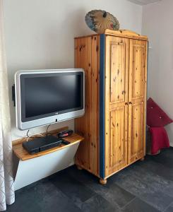 a tv sitting on a table next to a wooden cabinet at Ferienwohnung Vicus - am Fuße des Schaumberges in Tholey