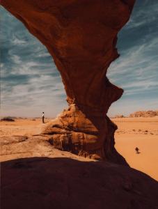 a man standing in a desert with a rock formation at Abdo waid rum in Aqaba