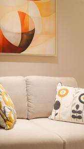 QuaiLuxe Haven Studio Comfort near Boulevard111的一张带两个枕头的白色沙发和绘画