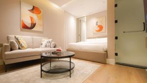 QuaiLuxe Haven Studio Comfort near Boulevard111的客厅里有一张沙发和一张桌子。