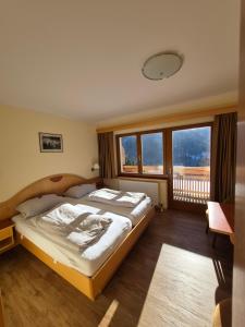 Un dormitorio con una cama grande y una ventana grande en Hotel Restaurant Raunig, en Bad Kleinkirchheim