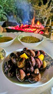 Un plato de mejillones en una mesa con cuencos de comida. en Simple home, en Madaba