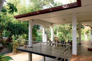 a screened in porch with chairs and tables at Brescia villa - Your Private Escape in matara in Gandara West