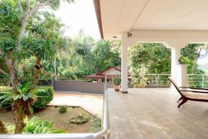a porch with a table and a bench and trees at Brescia villa - Your Private Escape in matara in Gandara West +40 photos