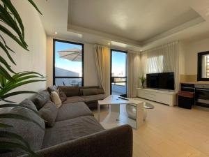 Una sala de estar con un sofá y un televisor en 2Bedroom Suite 7 with shelter, en Tel Aviv