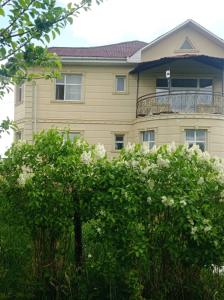 ein Gebäude mit Balkon auf einem Baum in der Unterkunft Гостевой дом Маман in Maman