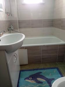ein Badezimmer mit einem Waschbecken, einer Badewanne und einem Teppich in der Unterkunft Гостевой дом Маман in Maman + 2 Fotos
