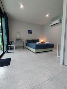 a bedroom with a bed and a table in it at Samui Land Haven in Amphoe Koh Samui