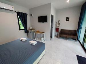 a bedroom with a blue bed and a television at Samui Land Haven in Amphoe Koh Samui
