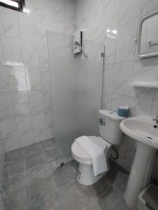 a white bathroom with a toilet and a sink at Samui Land Haven in Amphoe Koh Samui