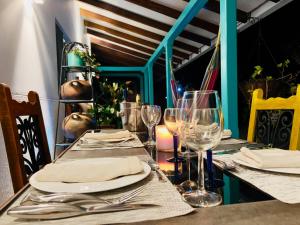 einen Tisch mit Tellern und Weingläsern darauf in der Unterkunft Finca Bella Village Para Amantes del Entorno Rural in Jiguales