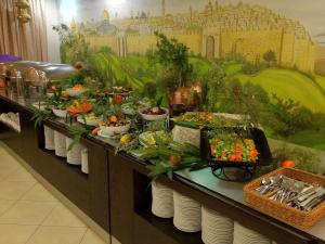 ein Buffet mit Vorspeisen und Salaten auf Tellern in der Unterkunft Commodore Hotel in Jerusalem