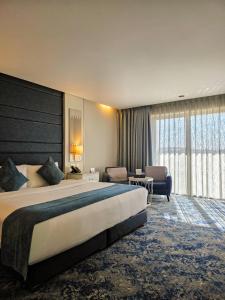 Una habitación de hotel con una cama grande y una ventana grande. en Opal Hotel Amman, en Amán