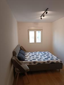 een slaapkamer met een bed en een stoel erin bij Gorgerous 2 Bed Apartment in Bar