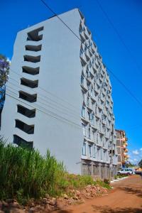 a tall white building on the side of a street at TSAVO Room 202 in Kiambu