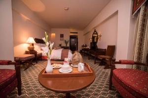 Una sala de estar con una mesa y una cama. en Sarena Hotel, en Quetta