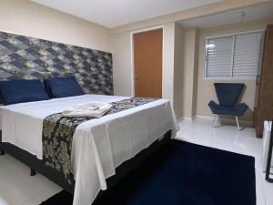 ein Schlafzimmer mit einem Bett und einem blauen Stuhl in der Unterkunft HOTEL LA SIERRA in Bodoquena + 62 Fotos